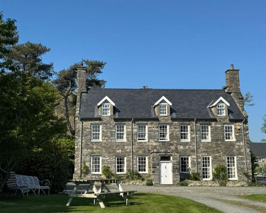 Large stone house with a garden on a clear day
